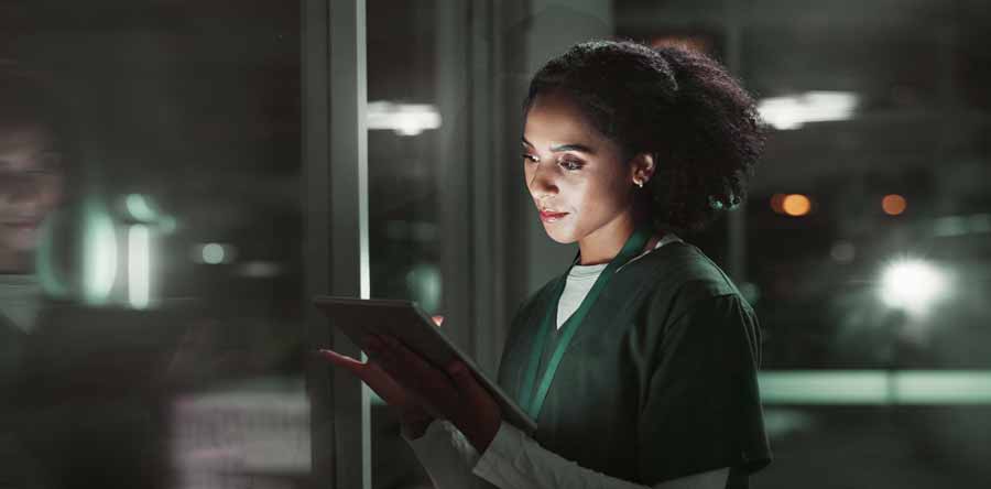 Un'infermiera controlla su un dispositivo mobile se ci sono persone cadute durante il turno di notte.