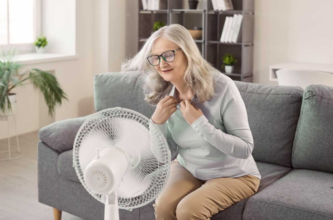 Donna anziana si rinfresca con un ventilatore. Un ambiente fresco è essenziale per la sicurezza degli anziani dal caldo.